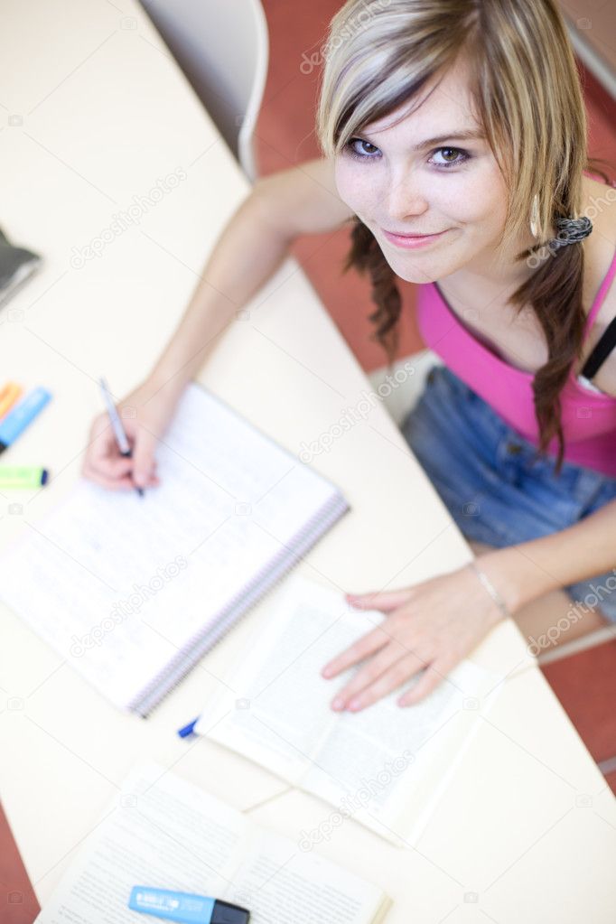 Portrait of a pretty young college student in a classroom (selec