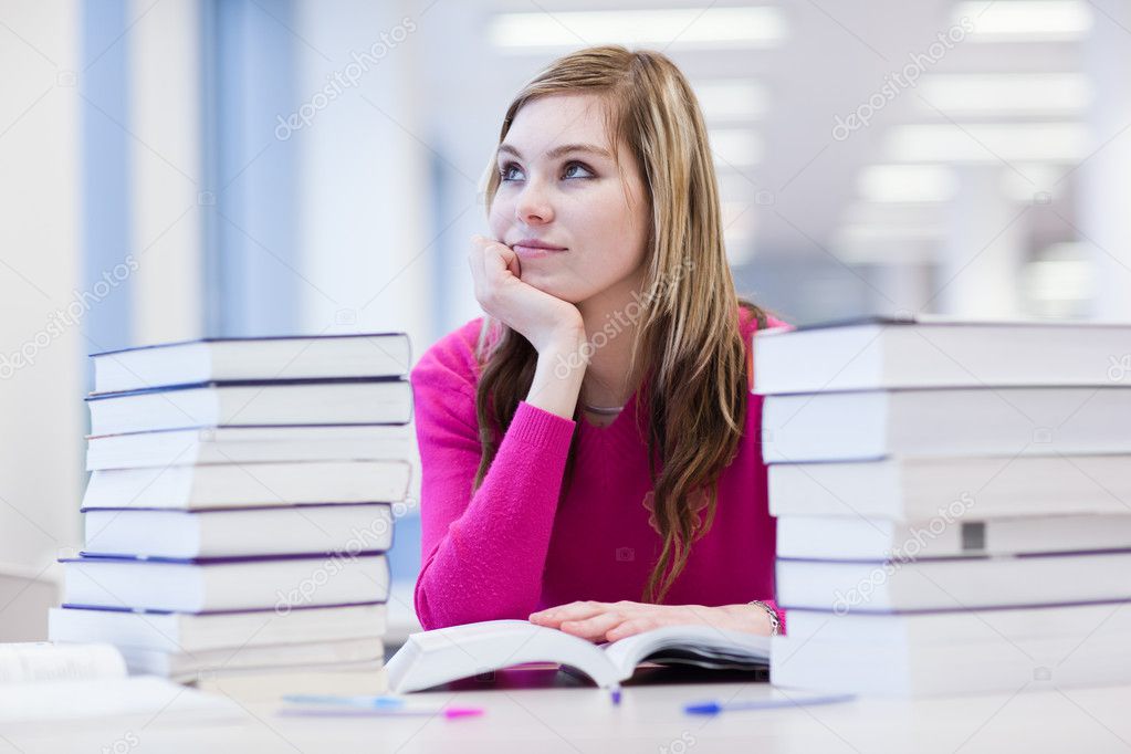 In the library - pretty, female student with laptop and books wo