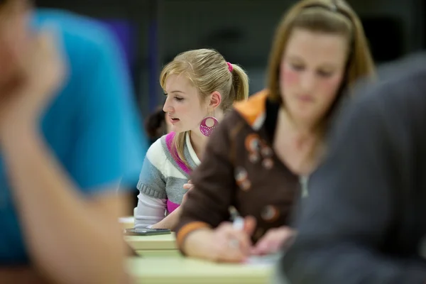 Csinos női főiskolai hallgató ül egy osztályteremben teljes ÖSZE — Stock Fotó