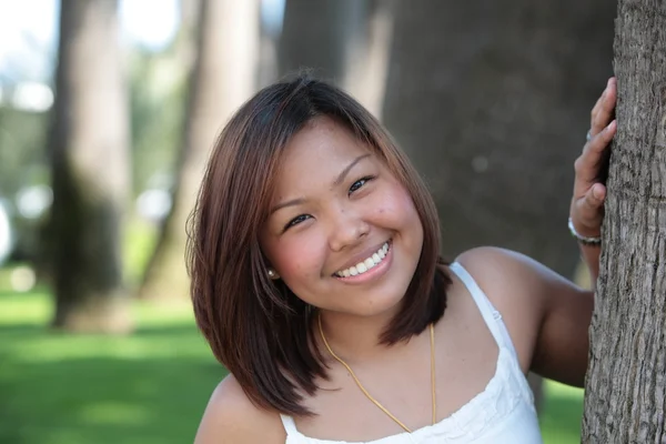 Porträtt av ganska ung asiatisk kvinna med ett härligt leende ser — Stockfoto
