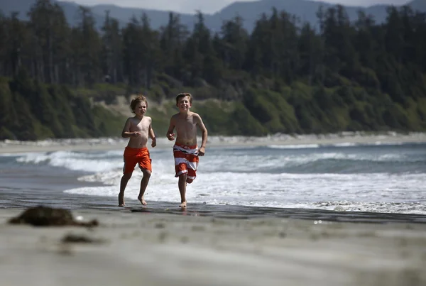 Мальчики бегут на пляже — стоковое фото