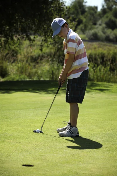 Chlapec hrát golf — Stock fotografie