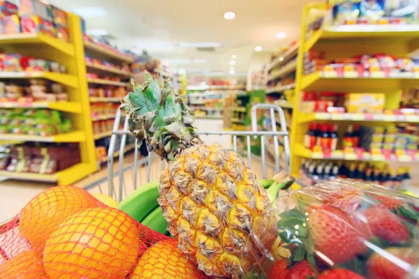 Moviendo carrito de compras en el supermercado . Fotos De Stock