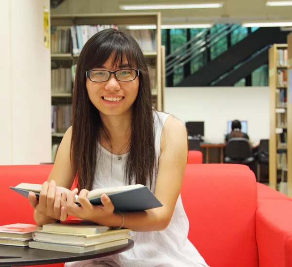 Menina asiática estudante na biblioteca — Fotografia de Stock