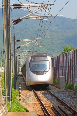 Fast train with passengers in Hong Kong at day clipart