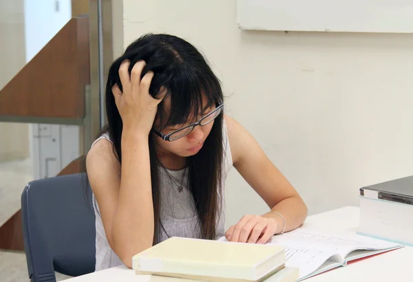 Asiatisk tjej student läsa och studera i biblioteket — Stockfoto