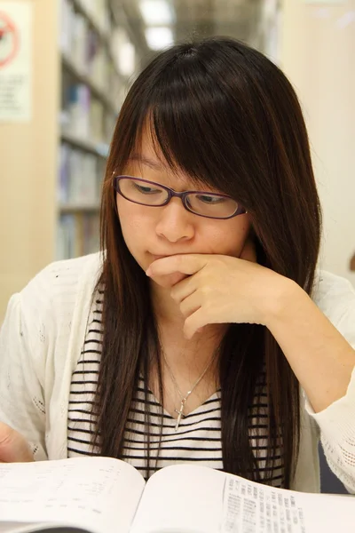 Asijská studentka v knihovně — Stock fotografie