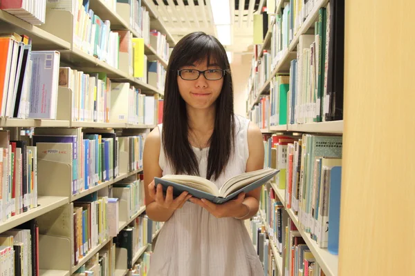 Jovem estudante universitário em biblioteca — Fotografia de Stock