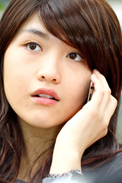 Ázsiai nő beszél telefonon, kíváncsi arccal — Stock Fotó
