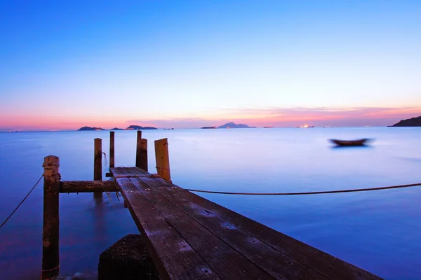 Ahşap bir iskele boyunca alacakaranlıkta günbatımı — Stok fotoğraf