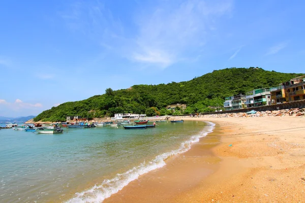 Pláž v hong Kongu s mnoha člunů a domy — Stock fotografie