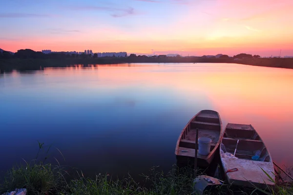 Sonnenuntergang am Teich mit einsamen Booten — Stockfoto