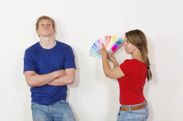 Giovane coppia guardando fuori il colore della parete — Foto Stock