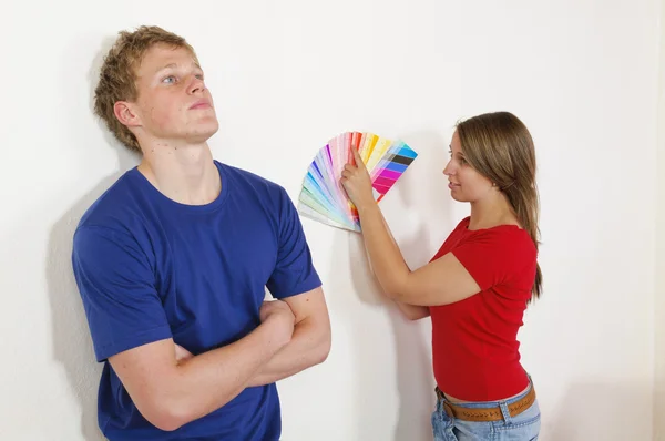 Νεαρό ζευγάρι ψάχνει έξω το χρώμα τοίχων — Φωτογραφία Αρχείου