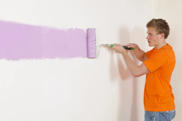 Молодий чоловік малює стіну — стокове фото