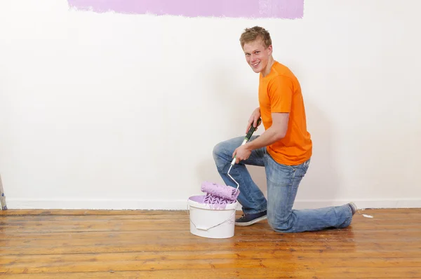 Mladý muž maluje zeď — Stock fotografie