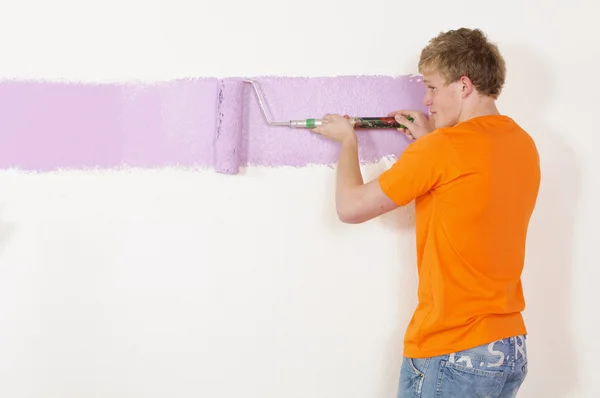 Ung man målar en vägg — Stockfoto