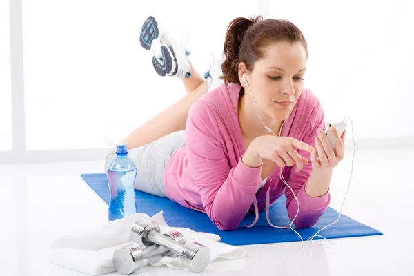 Fitness žena poslouchat hudbu mp3 relax tělocvična — Stock fotografie