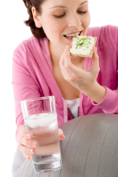Женщина расслабляется, закусывая стаканом воды — стоковое фото