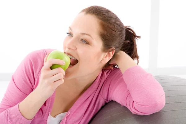 Fitness kvinna äta äpple sportig outfit — Stockfoto