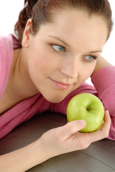 Женщина ест яблоко в спортивном наряде — стоковое фото