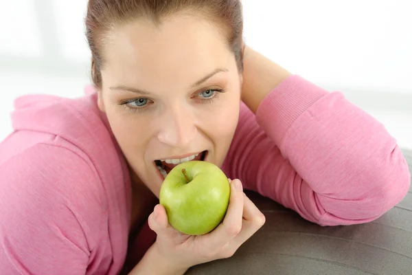 Fitness woman eat apple sportive outfit — Stock Photo, Image