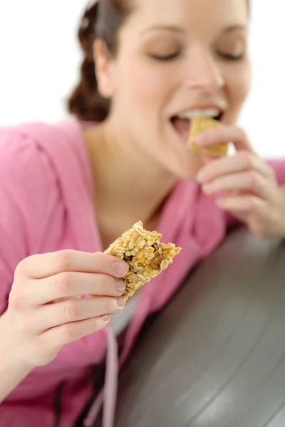 Fitness woman eat granola sportive outfit happy — Stock Photo, Image
