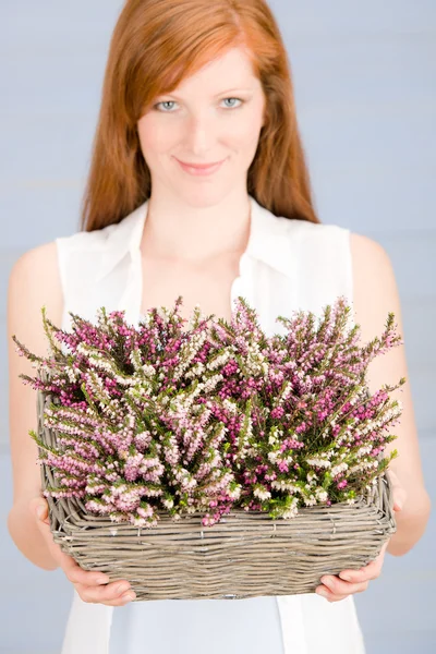 Sommerrothaarige Frau hält Korb mit Blumen — Stockfoto