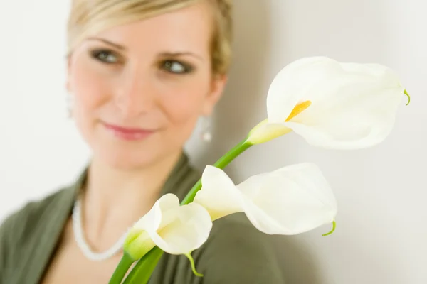Calla liliom virág nő háttérben portréja — Stock Fotó