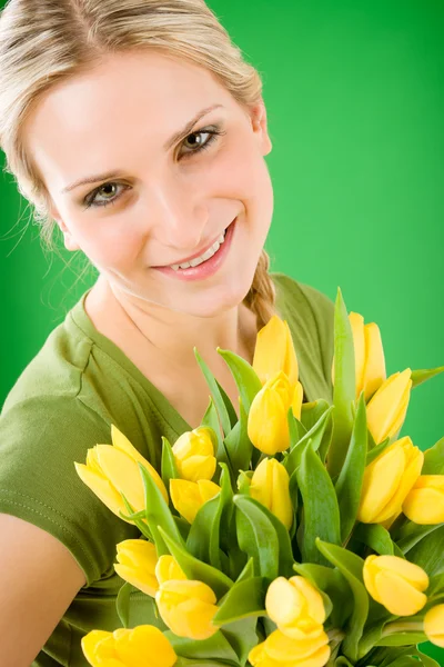 Mujer joven sostiene tulipanes amarillos flor — Foto de Stock