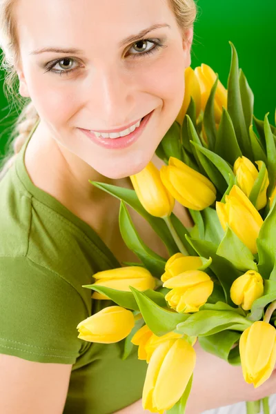 Jovem mulher segurar amarelo tulipas flor — Fotografia de Stock