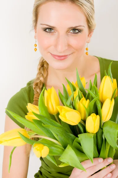 Молодая женщина держит желтый цветок тюльпанов — стоковое фото