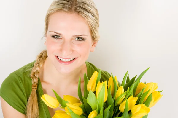 Jonge vrouw houdt geel tulpen bloem — Stockfoto