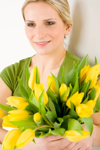 Молода жінка тримає жовту квітку тюльпанів — стокове фото