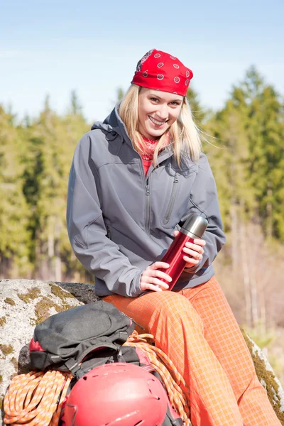 Actieve vrouw rotsklimmen met thermosbottle — Stockfoto