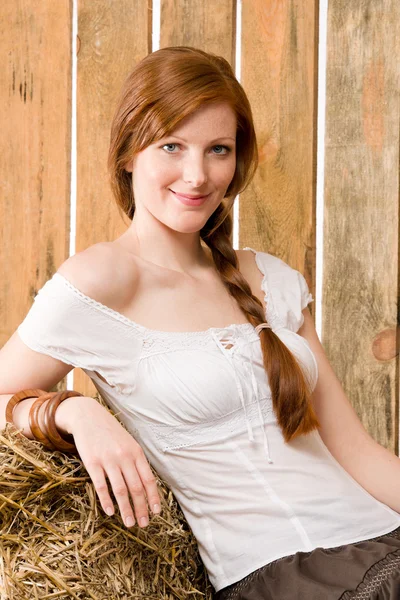 Romantic young woman sitting on hay barn — Stock Photo, Image