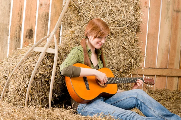 在谷仓里的年轻国家的女人玩吉他 — 图库照片