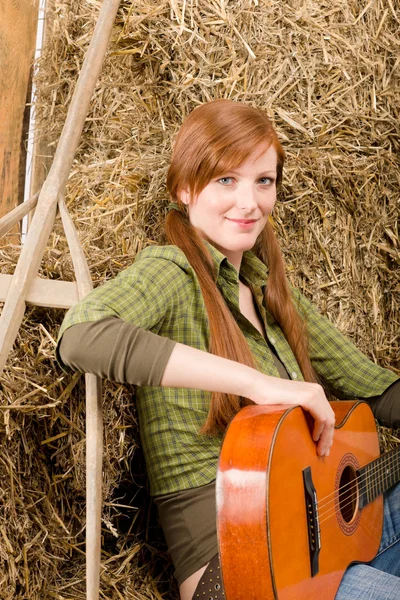 Молода заміська жінка грає на гітарі в сараї — стокове фото
