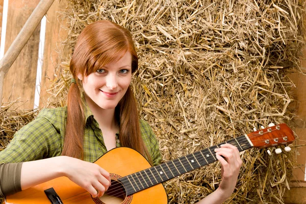 Jonge land vrouw gitaarspelen in schuur — Stockfoto
