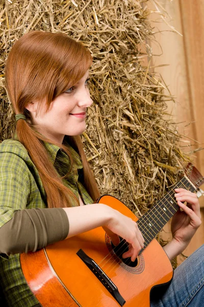 Kobieta młody kraj gra na gitarze w stodole — Zdjęcie stockowe