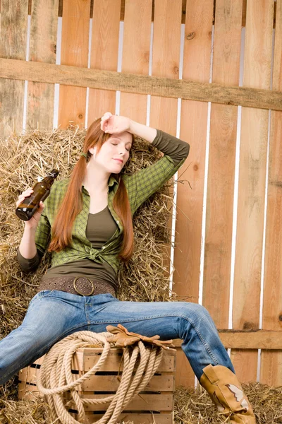 Provocante jovem cowgirl beber cerveja no celeiro — Fotografia de Stock