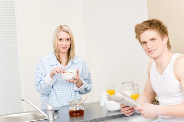 Desayuno feliz pareja comer cereal leer periódico —  Fotos de Stock