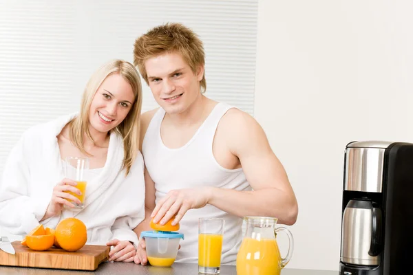 Pequeno-almoço casal feliz fazer manhã suco de laranja — Fotografia de Stock