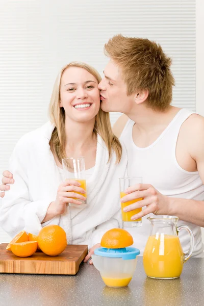 Pareja besándose desayuno disfruta de jugo de naranja — Stok fotoğraf