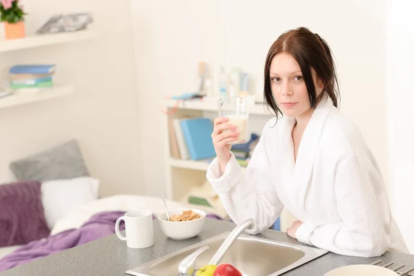 Молодая студентка завтракает на кухне — стоковое фото