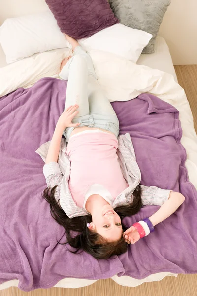 Young happy student relax lying on bed — Stock Photo, Image