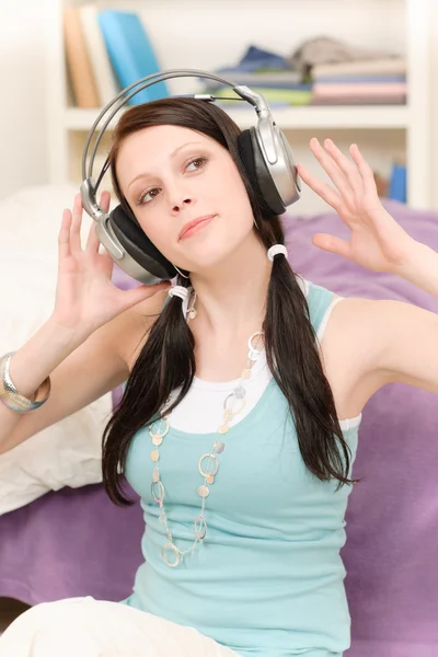 Молодой счастливый студент в наушниках слушает музыку — стоковое фото