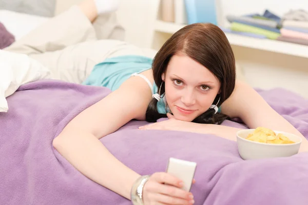 Jovem estudante menina na cama segurar telefone — Fotografia de Stock