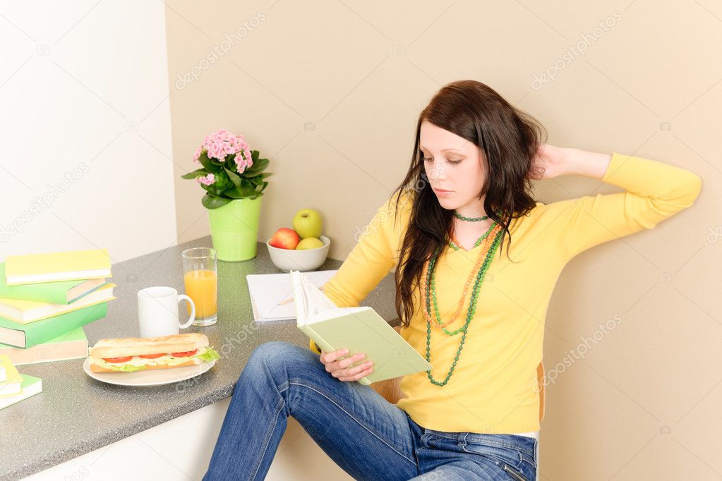 Young student girl reading book at home