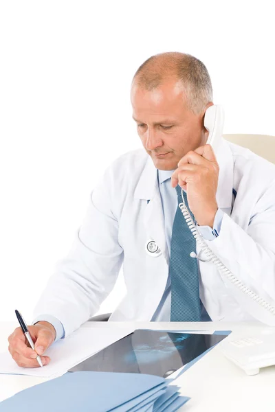 Reifer Arzt mit Röntgenbild am Telefon — Stockfoto